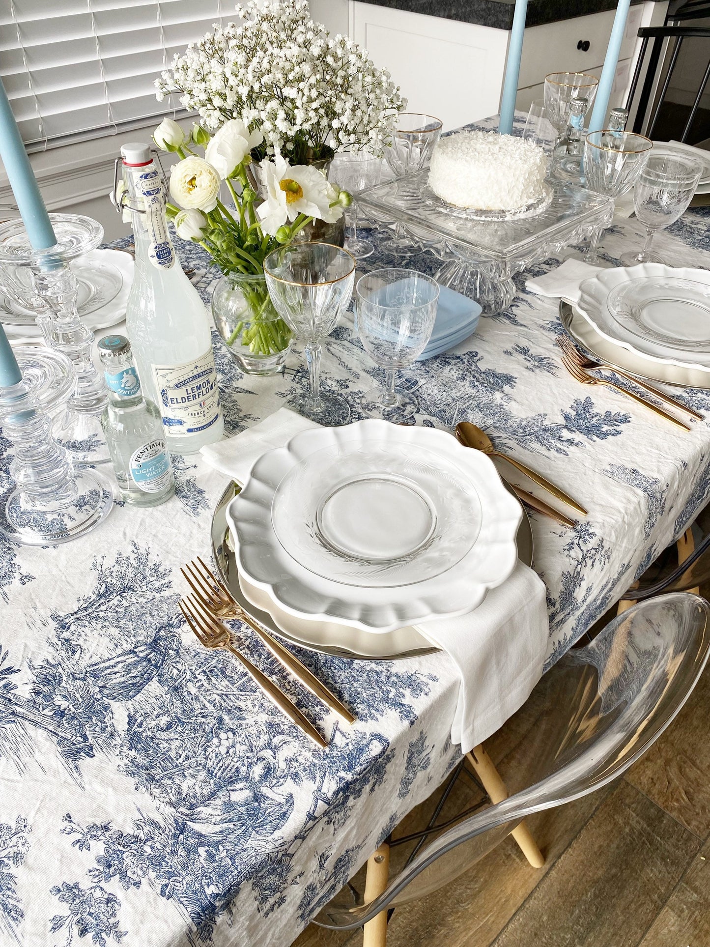 Italian washed cotton blue toile chinoiserie tablecloth laid on a dining table