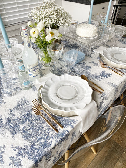 Italian washed cotton blue toile chinoiserie tablecloth laid on a dining table